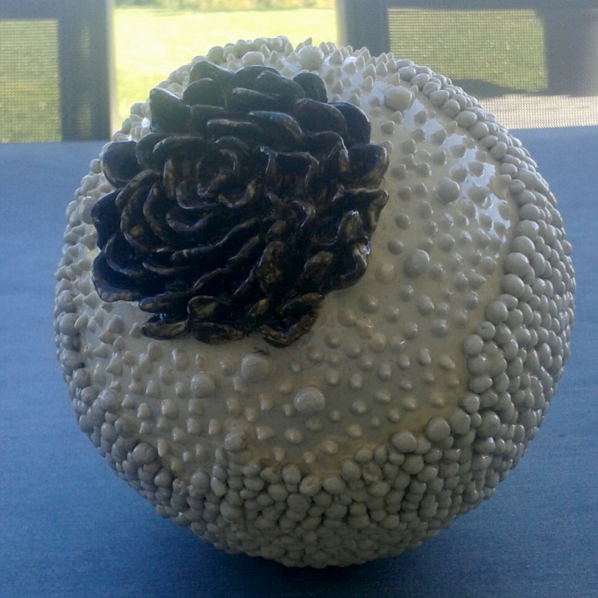 Boule de terre décorée d'une fleur noire